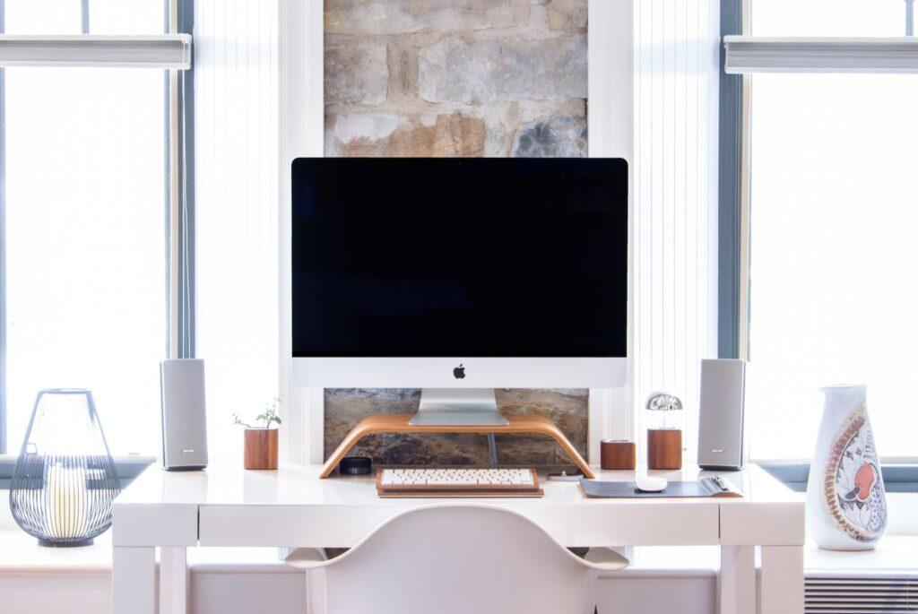 white iMac on top white desk