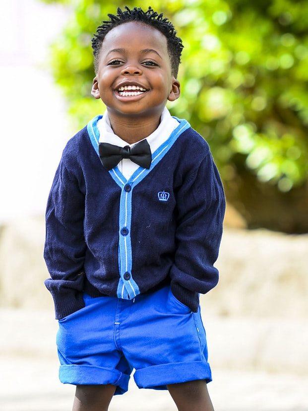 selective focus photo of boy standing on grey pavement